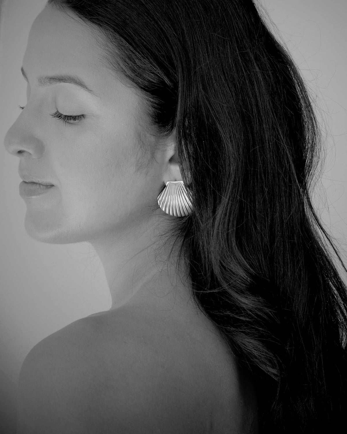 model wears silver shell earrings