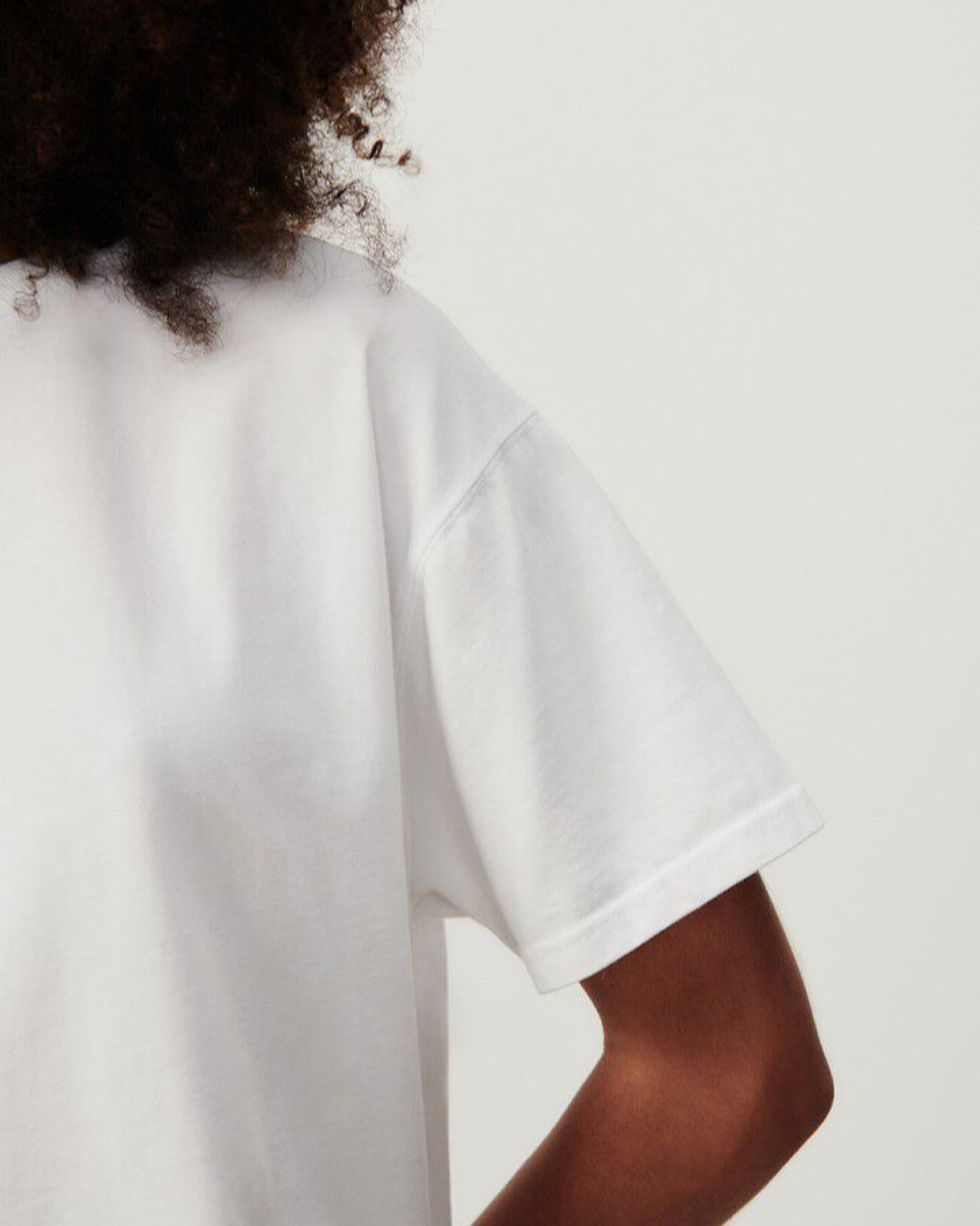 A model wears a white round neck tee with short sleeves