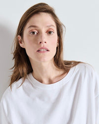 Person wearing a white shirt against a plain background
