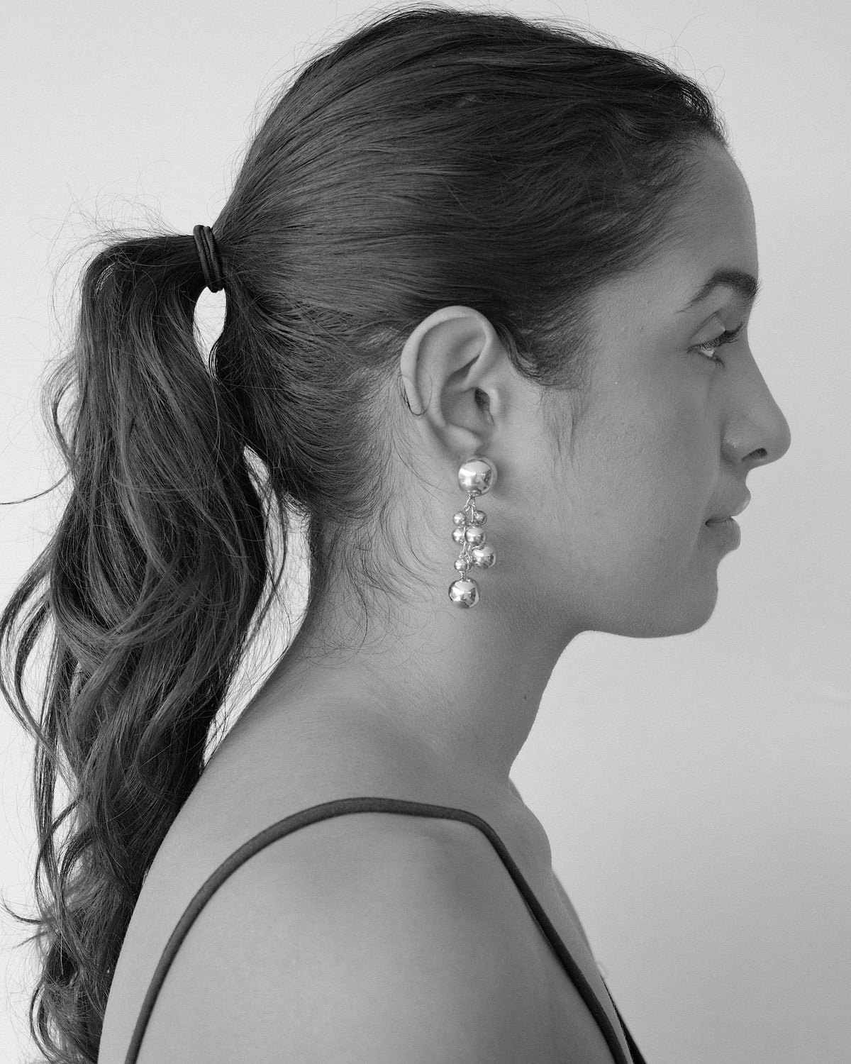 a model wears large ball earrings