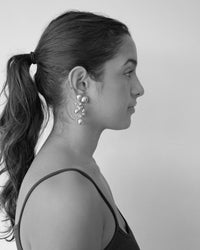 Model wears two fleur earrings side by side