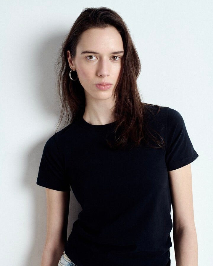 Person wearing a black t-shirt against a white background