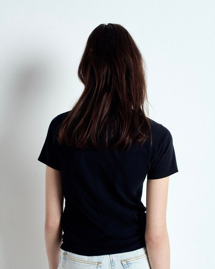 Person wearing a black t-shirt against a plain background
