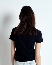 Person wearing a black t-shirt against a plain background