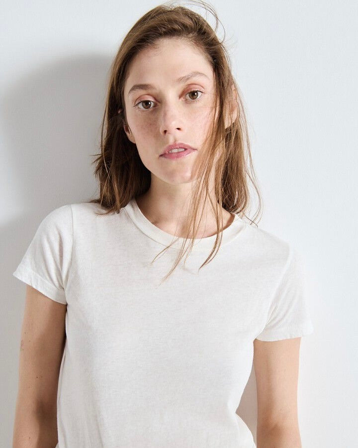 Person wearing a plain white t-shirt by American vIntage against a light background