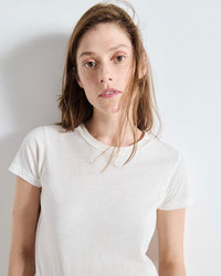 Person wearing a plain white t-shirt by American vIntage against a light background