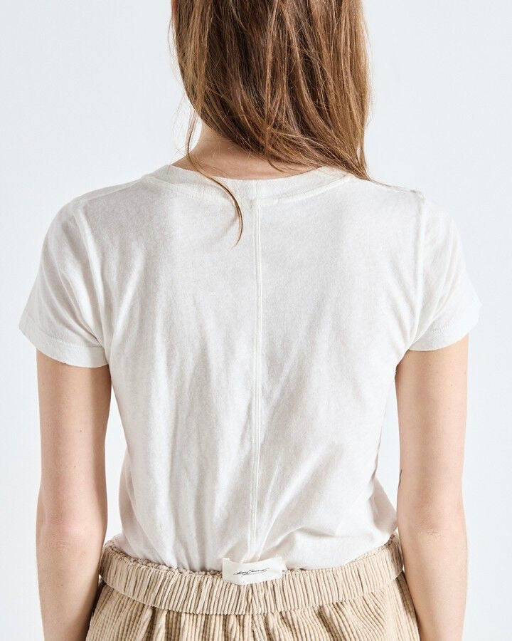 Person wearing a plain white t-shirt on a light background