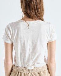 Person wearing a plain white t-shirt on a light background