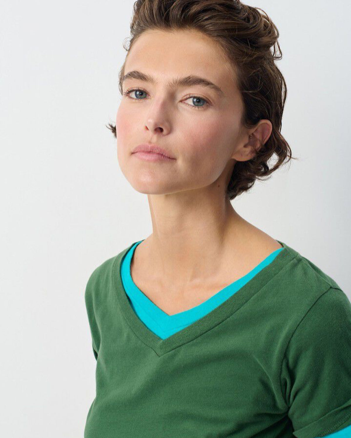 model wears a green and blue v neck tee