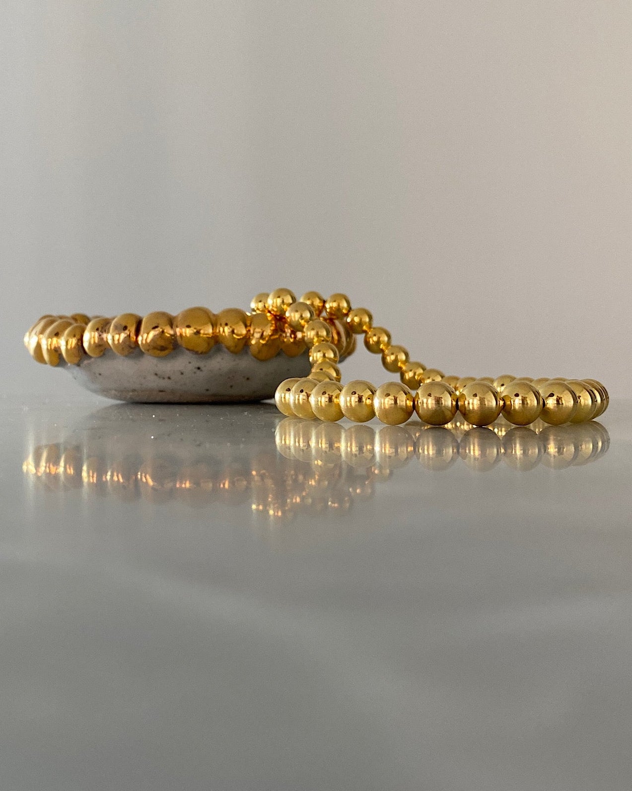 gold ball necklace on a marble background