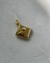 an small gold envelope with pearl clasp charm