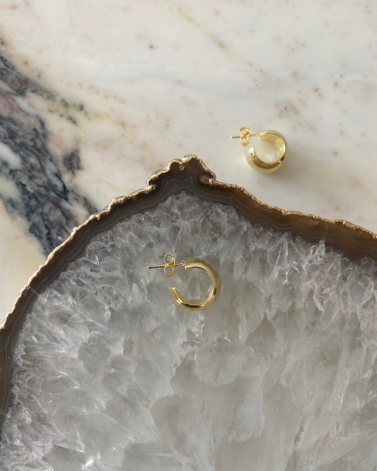 small gold wide hoop earrings on crystal