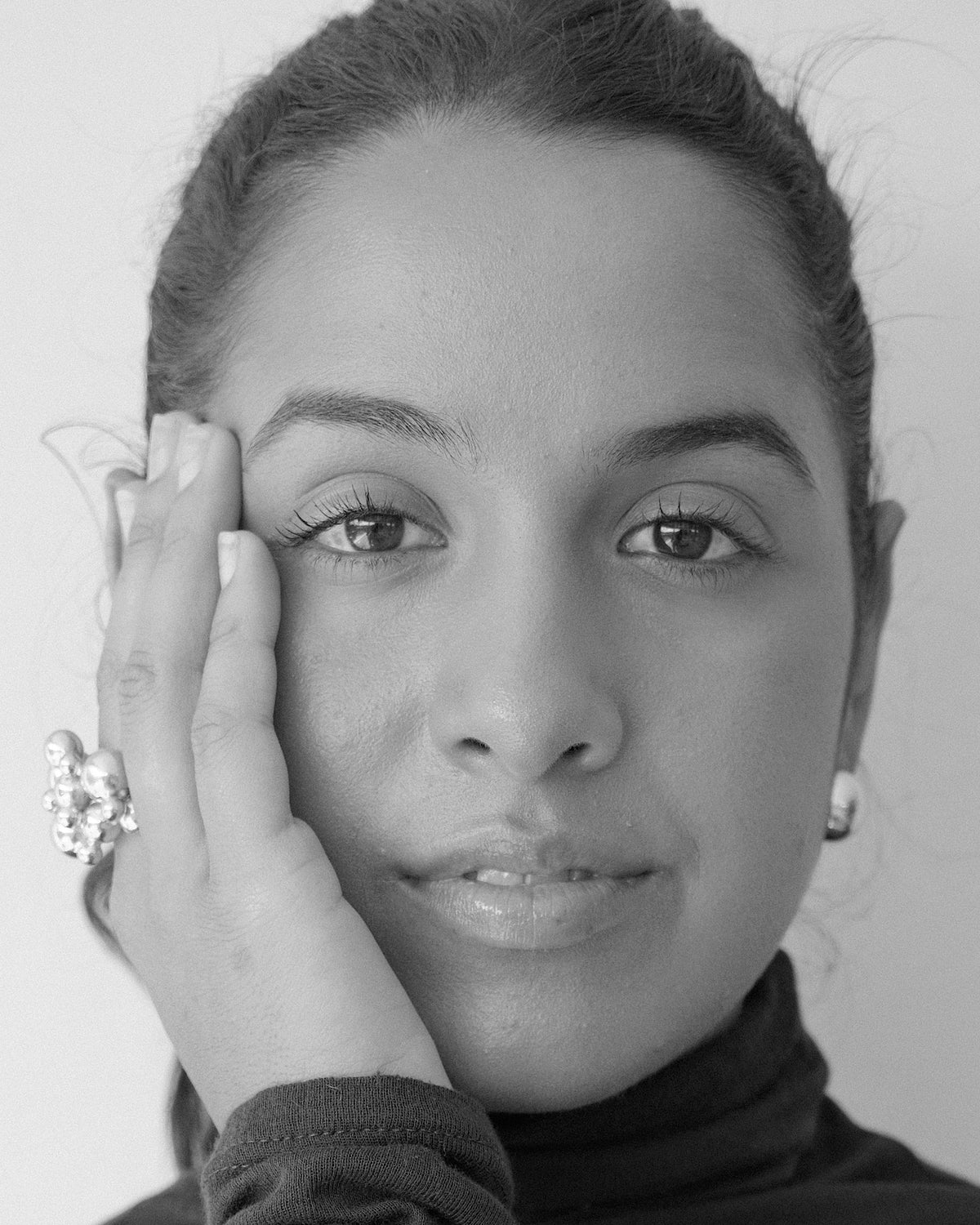 model wears a bubble ring and gold earrings