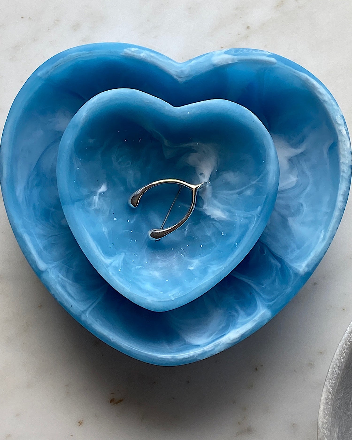 two blue resin hearts - one has a wishbone brooch