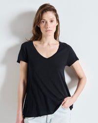 Woman wearing a black t-shirt against a plain background