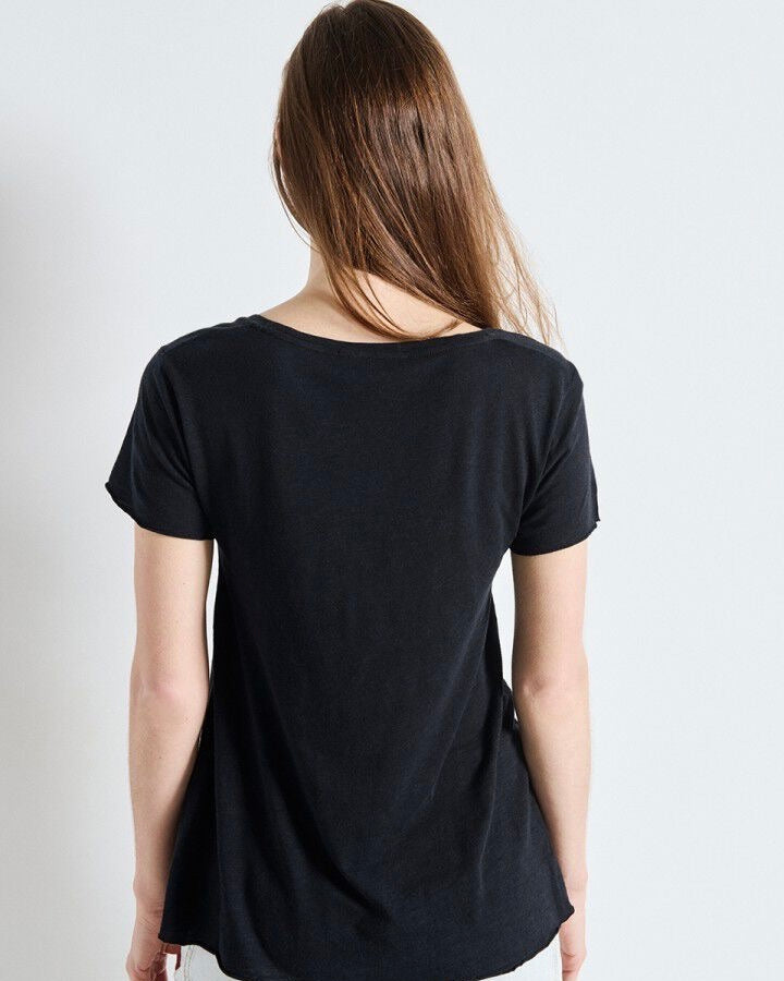 Person wearing a black t-shirt against a plain background