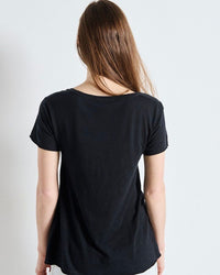 Person wearing a black t-shirt against a plain background