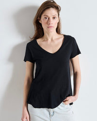 Woman wearing a black t-shirt against a plain background