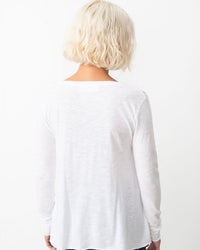 Person wearing a white long-sleeve shirt on a white background