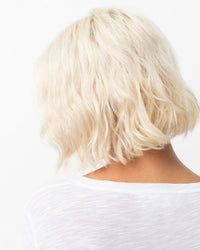 White haired woman wearing a white t