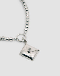 a silver charm necklace with a envelope charm attached