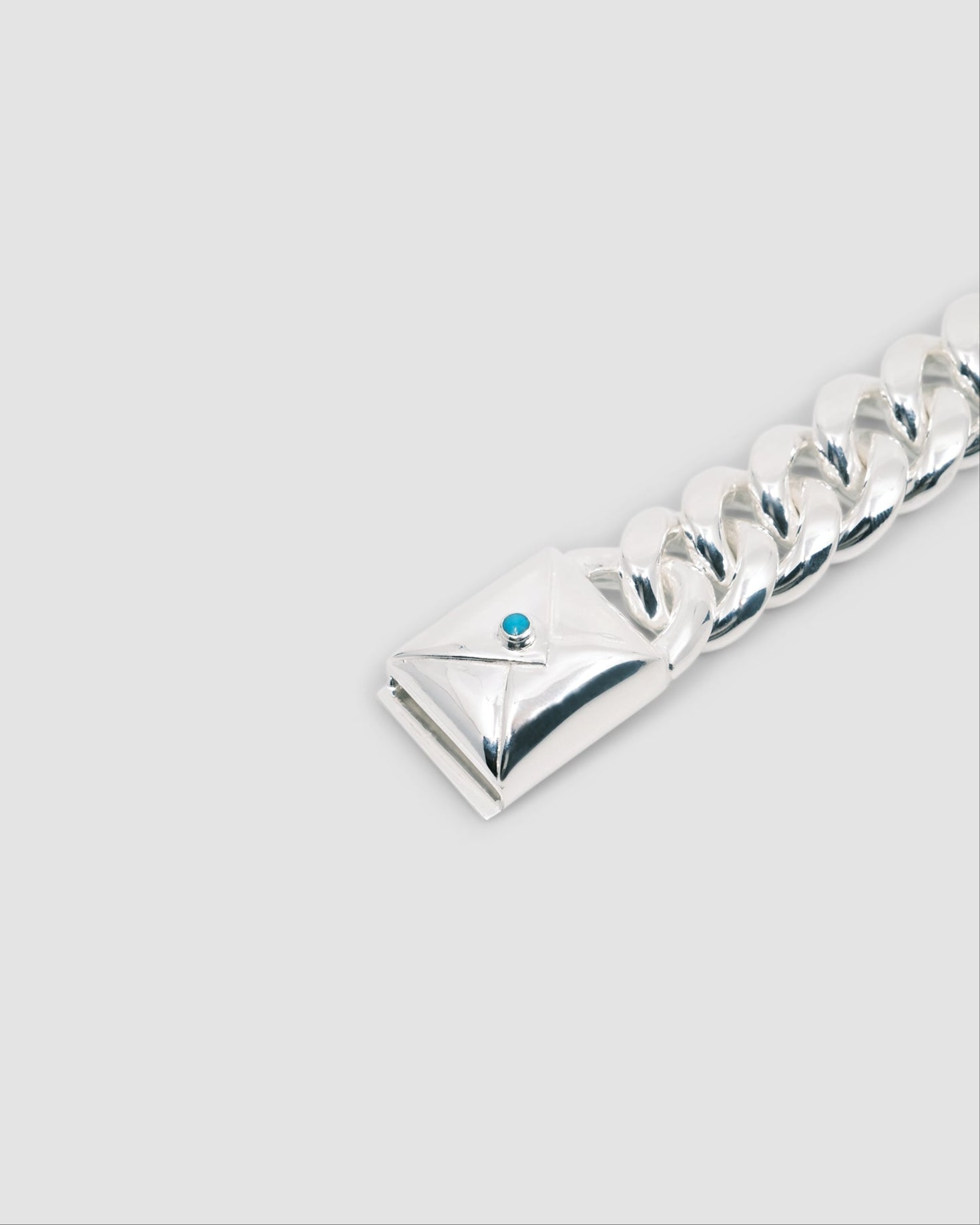 silver cuban link bracelet with a turquoise embellished envelope