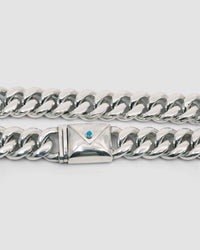 a large silver cuban link necklace with an envelope clasp with a blue stone