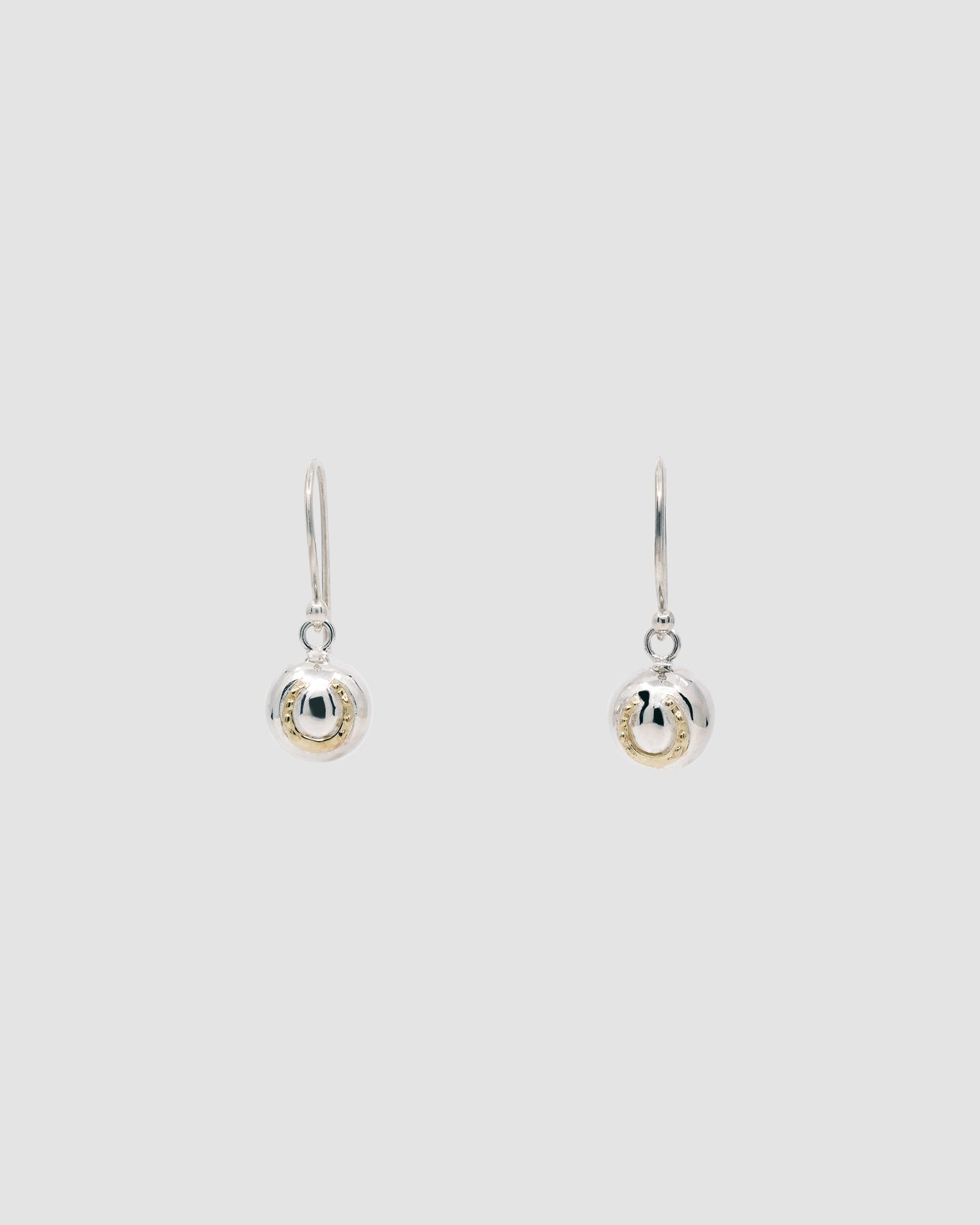 Silver ball drop earrings with a hook featuring a gold horse shoe