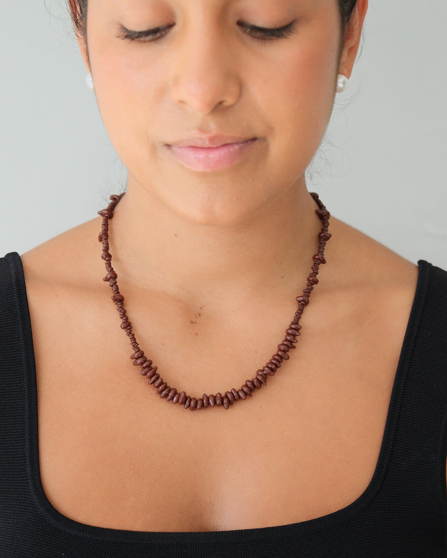 model wears a brown glass bead necklace