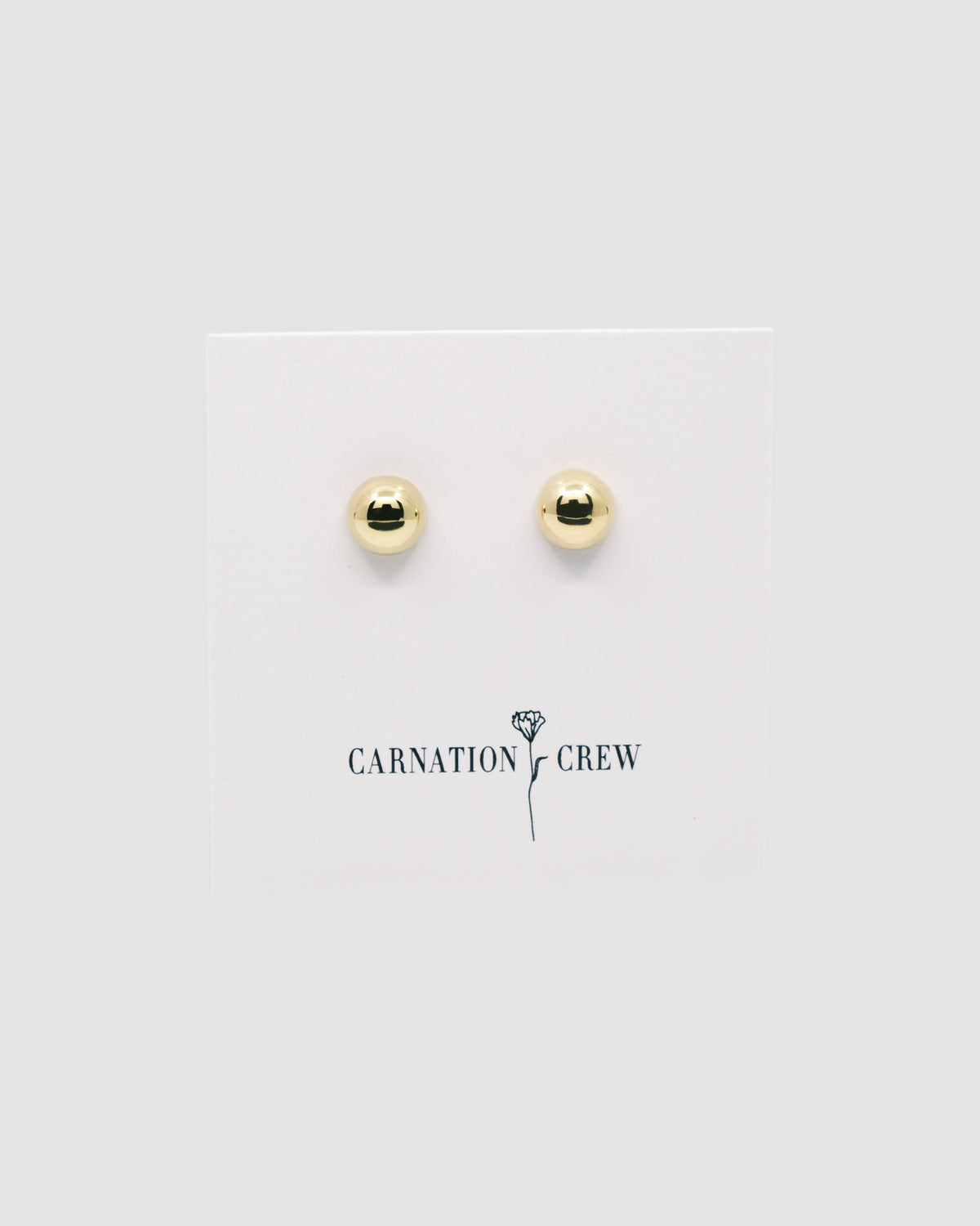 gold dome earrings on a carnation crew card