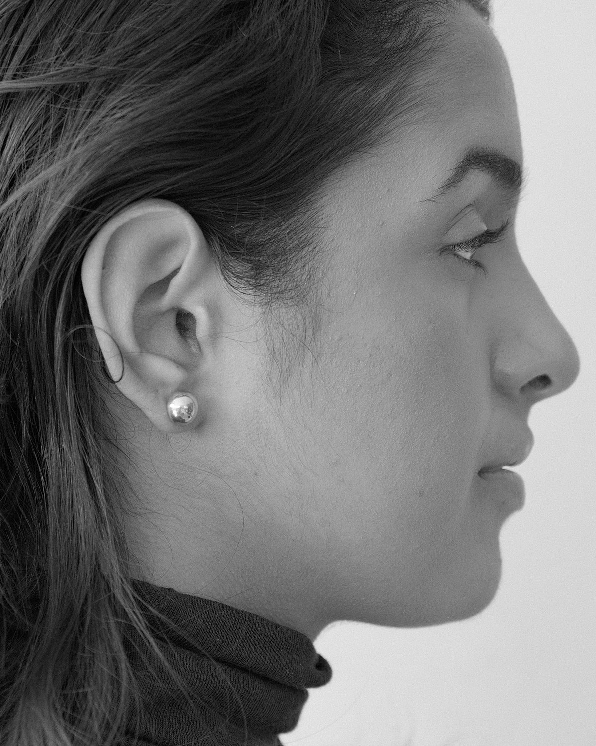 model wears simple dome stud earrings