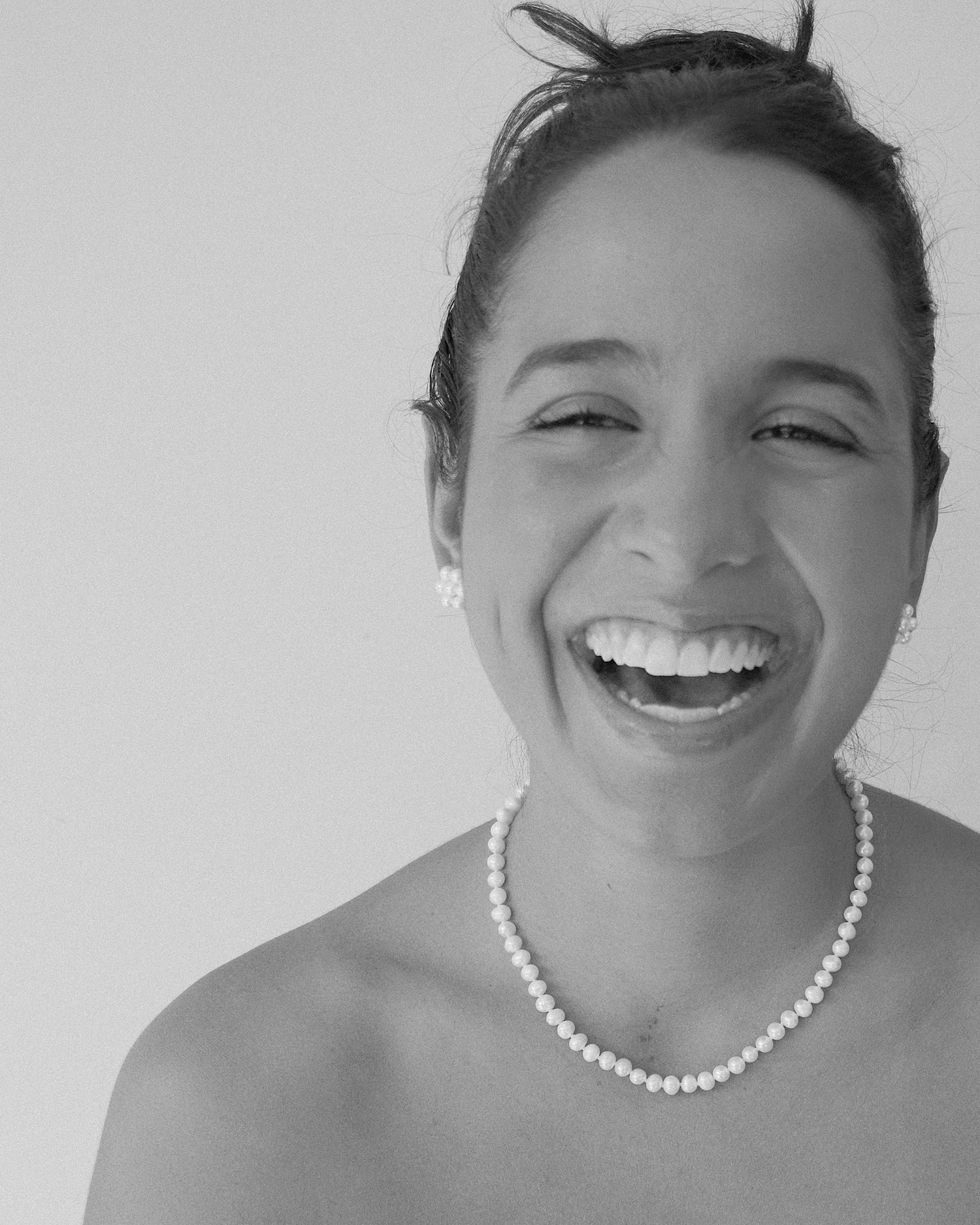 model wears a short pearl necklace and pearl flower earrings