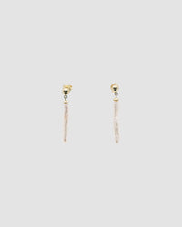 long skinny pearls dangle from a small gold stud earring