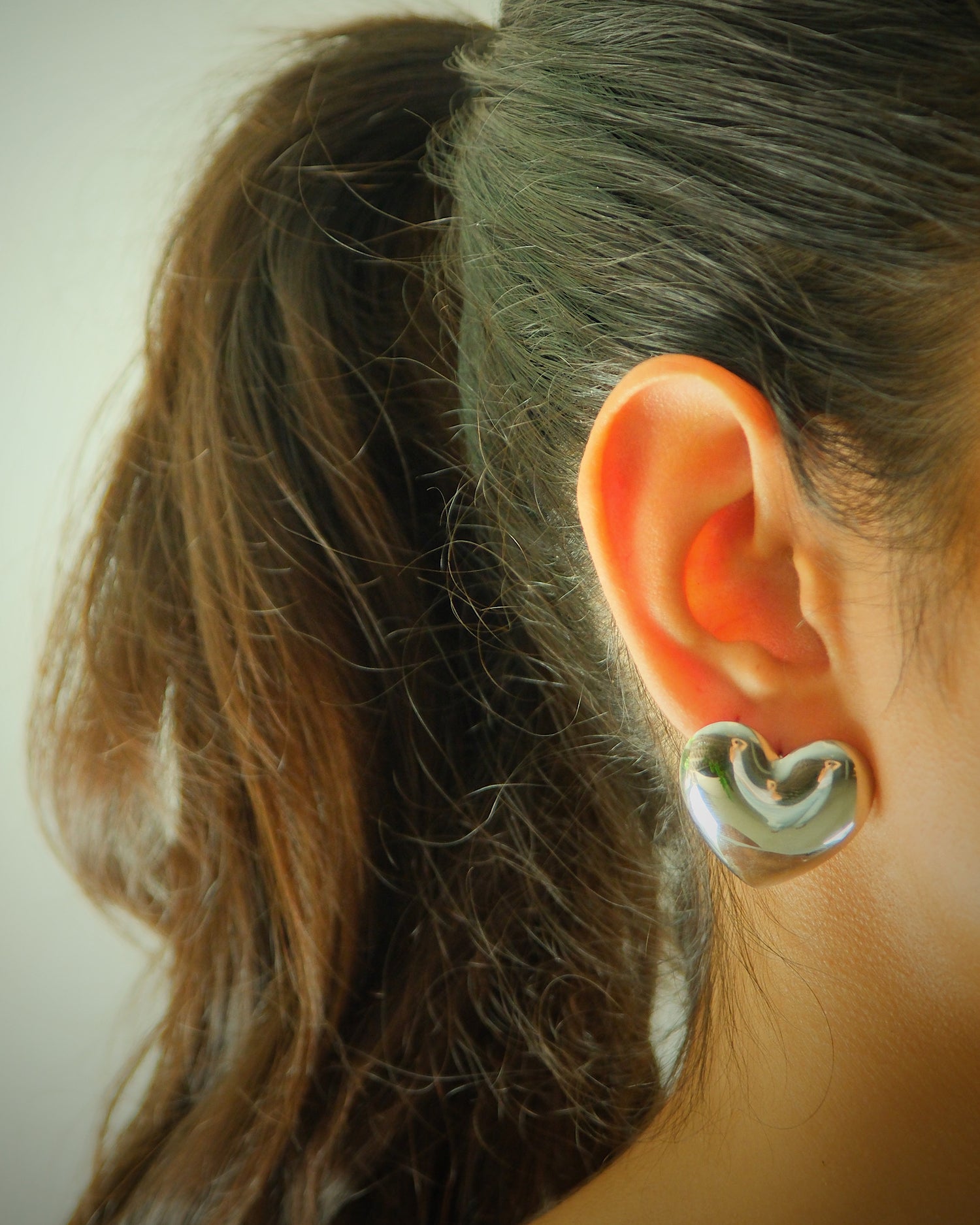 Model wears baby silver heart earrings