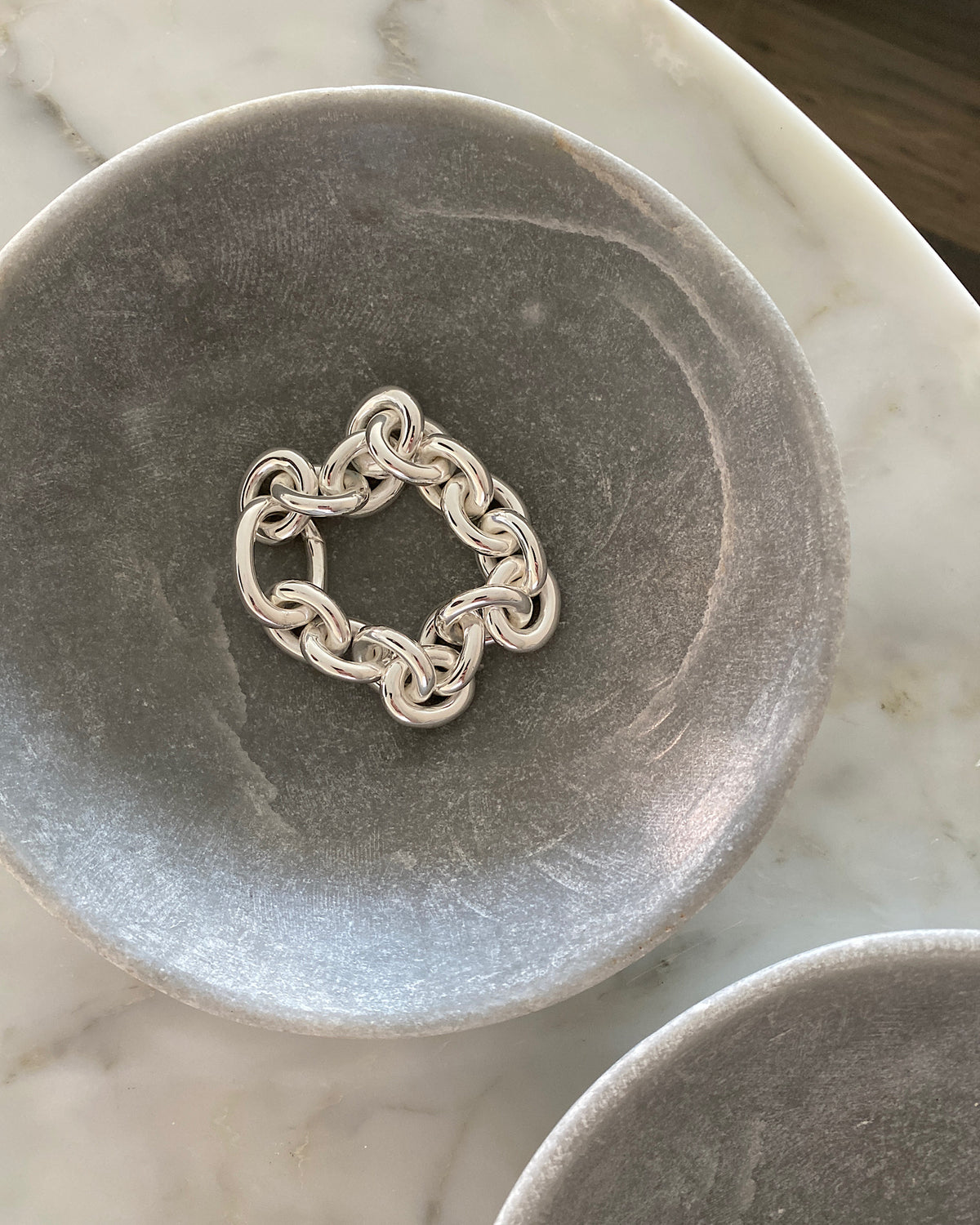 Large chain silver bracelet in a stone bowl