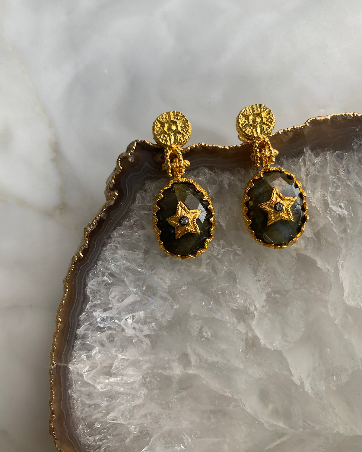 Green blue Crystal stone earrings sudded with a gold star and finished with a gold ornate stud textured top on a crystal platter