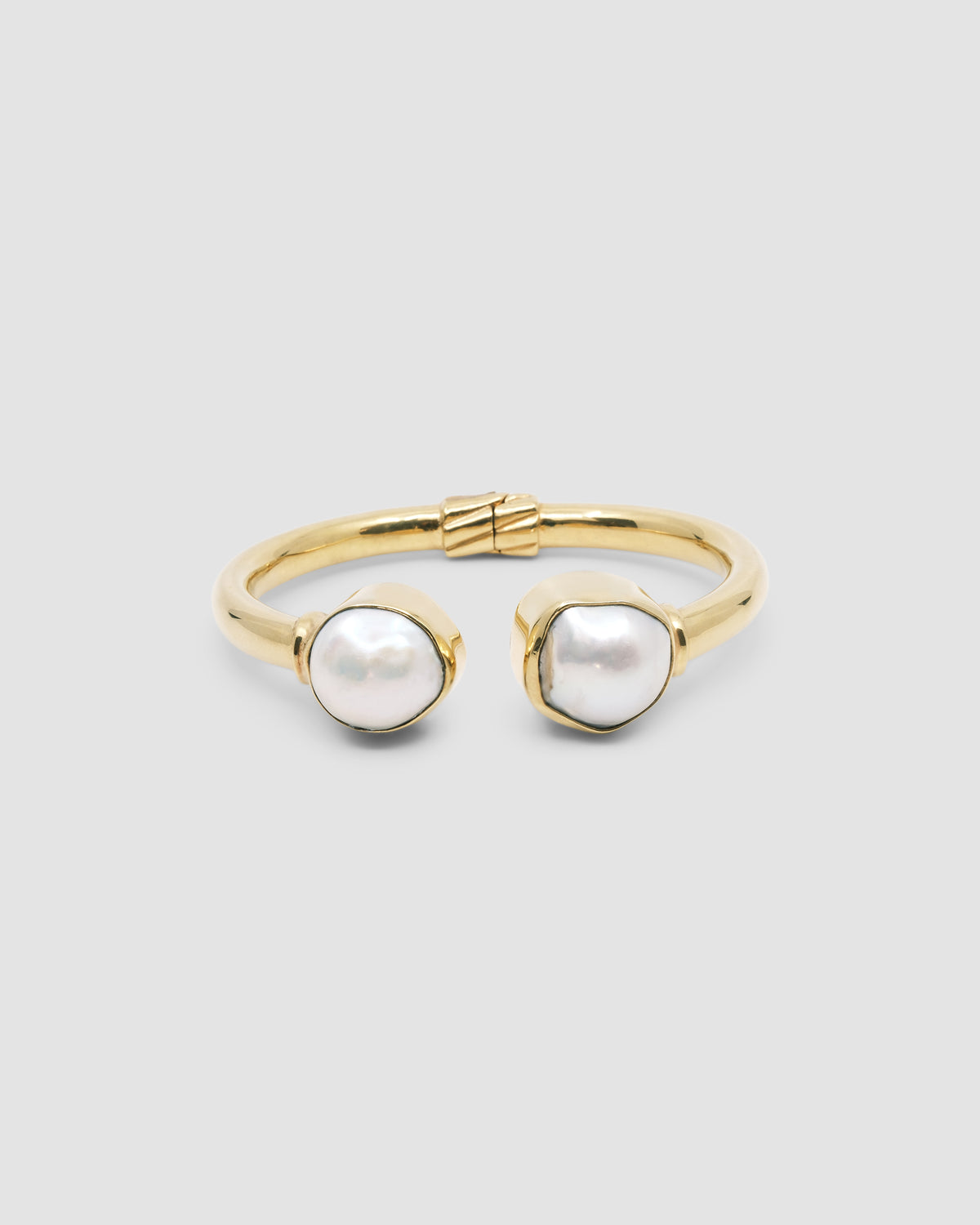 a gold cuff with baroque pearl ends