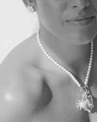 closeeup of a pearl charm necklaces on a model