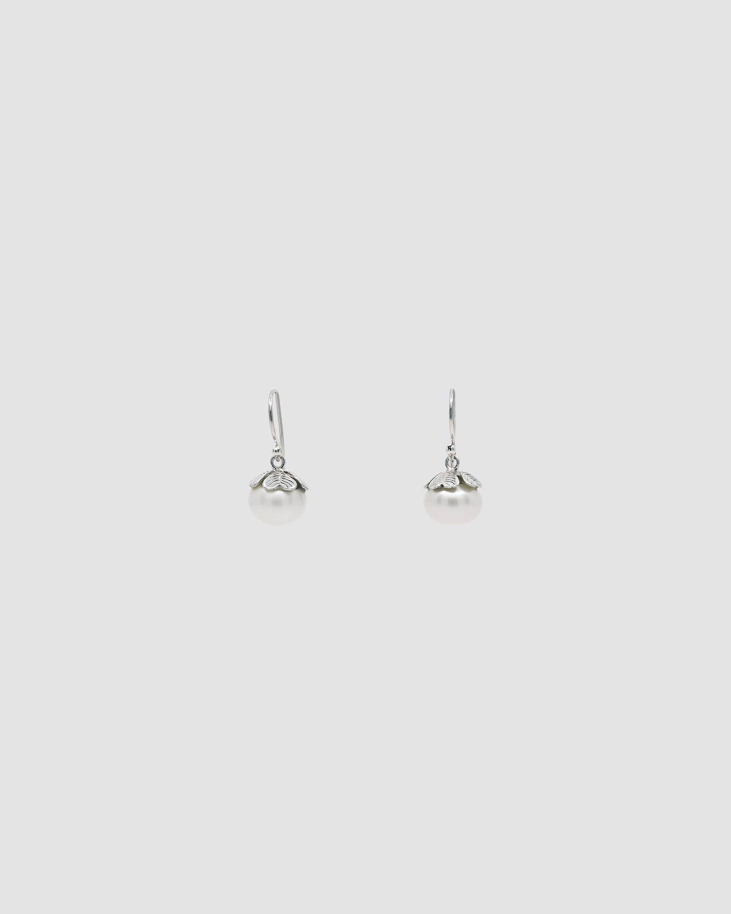 Silver hook earrings with pearls encased in a clover leaf top