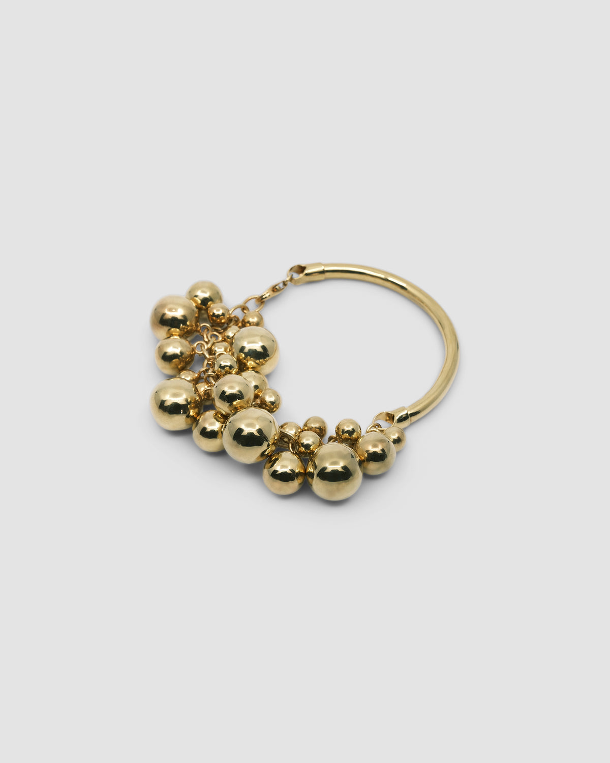 a gold bangle with a group of various shaped gold balls attached to half