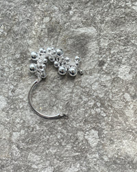 Silver ball and band bangle sits on concrete