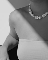 model wears a short pearl necklace