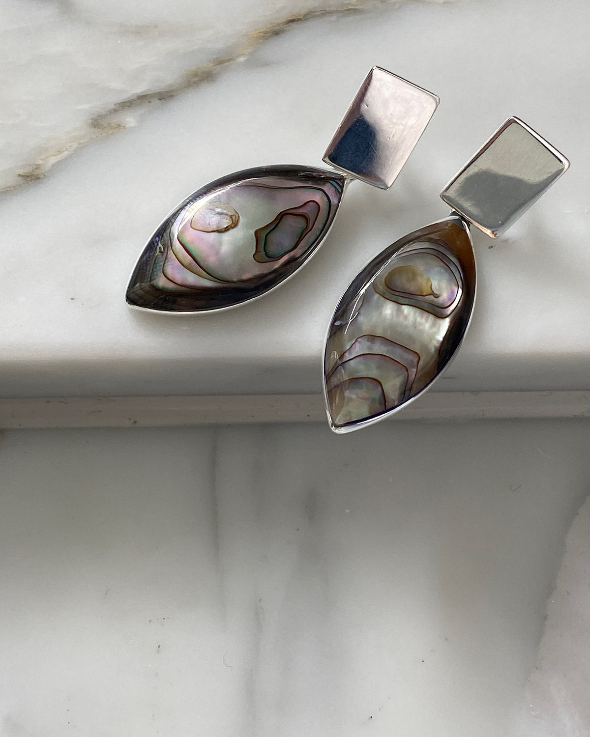 Sustainable Abalone & silver earrings sit on marble available in Australia at The Pared Store