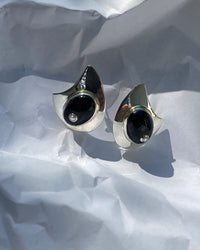 organic shaped silver earrings with a large onyx stone with a pearl centre