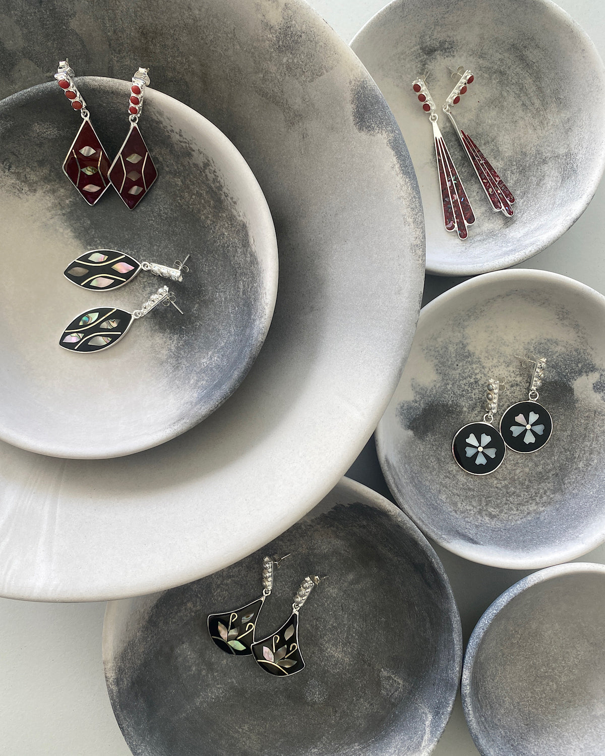 series of abalone earrings in grey bowls