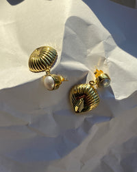 Pearl stud with gold shell like drop earring on paper