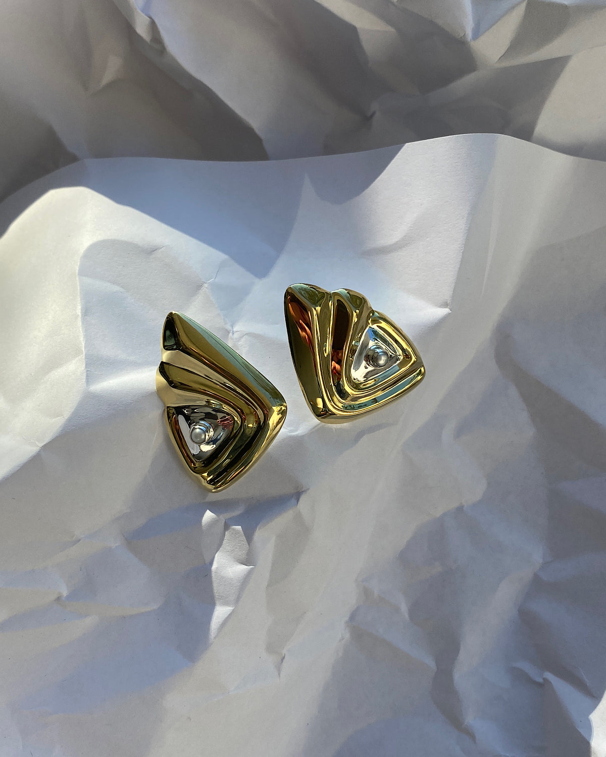 large gold and silver triangle shaped statement earrings with a single pearl stud