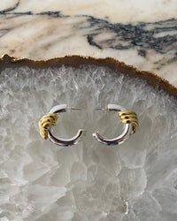 Gold wrapped silver hoop earrings on a crystal platter