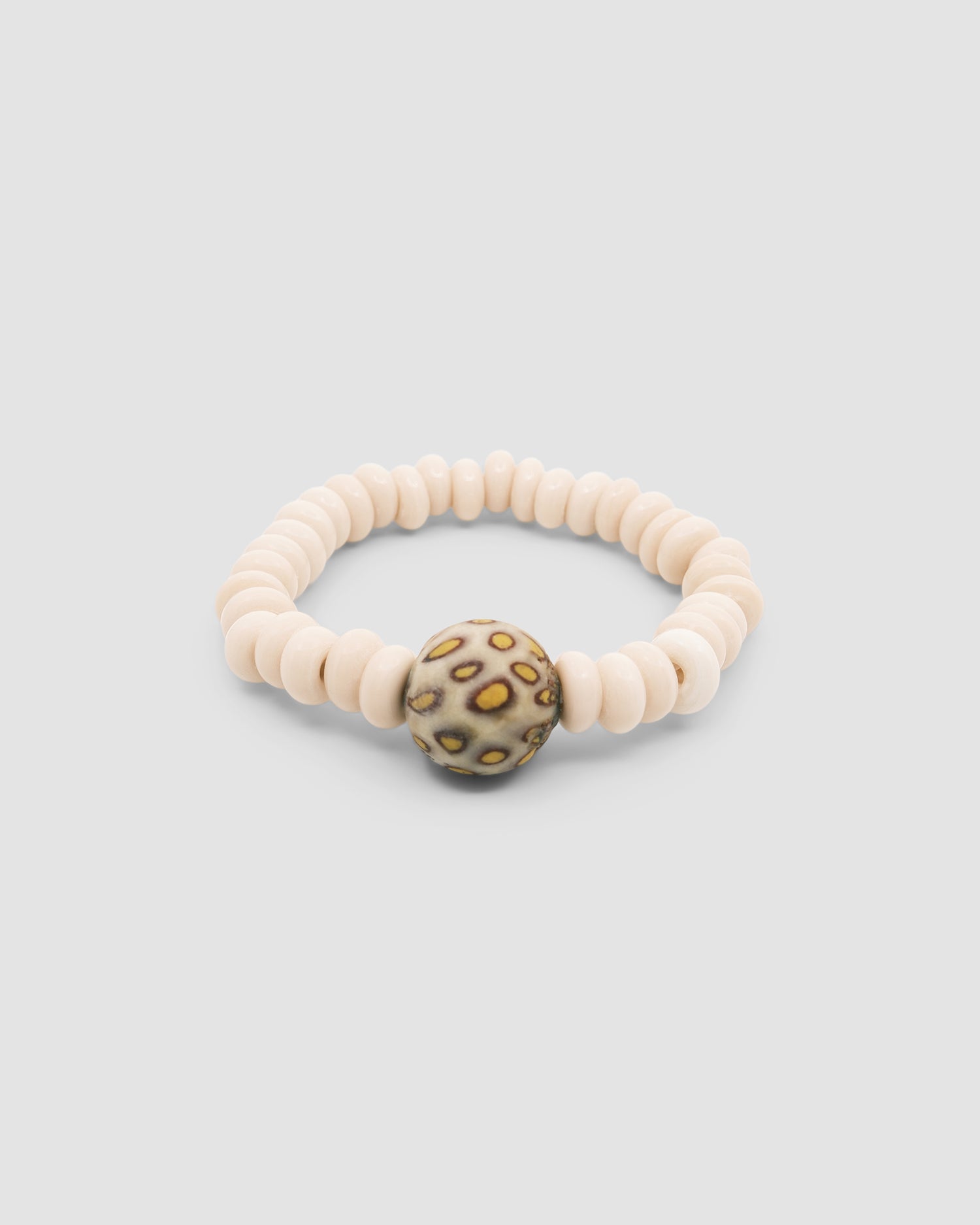 cream beaded bracelet with a central cream & yellow mottled feature bead