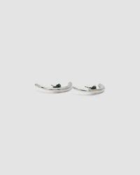 curved silver bar earrings lie on a grey background